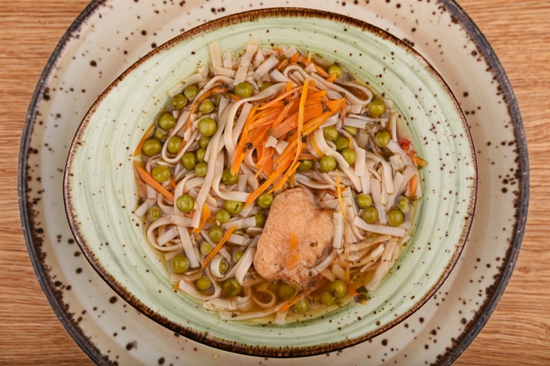 Gluten-free japanese hot chicken soup with rice noodles and vegetables