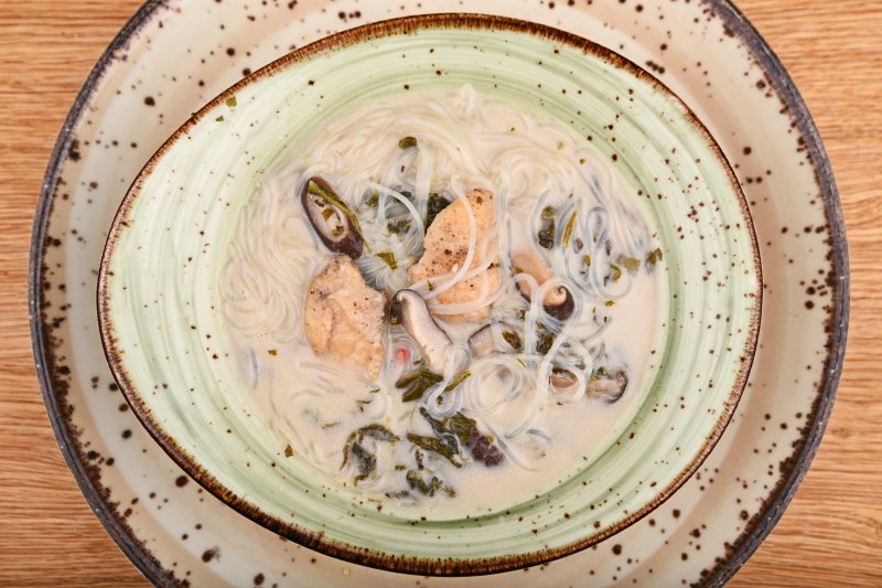 Hot chicken soup with lime, spinach, shiitake mushroom, coconut milk and cellophane noodles